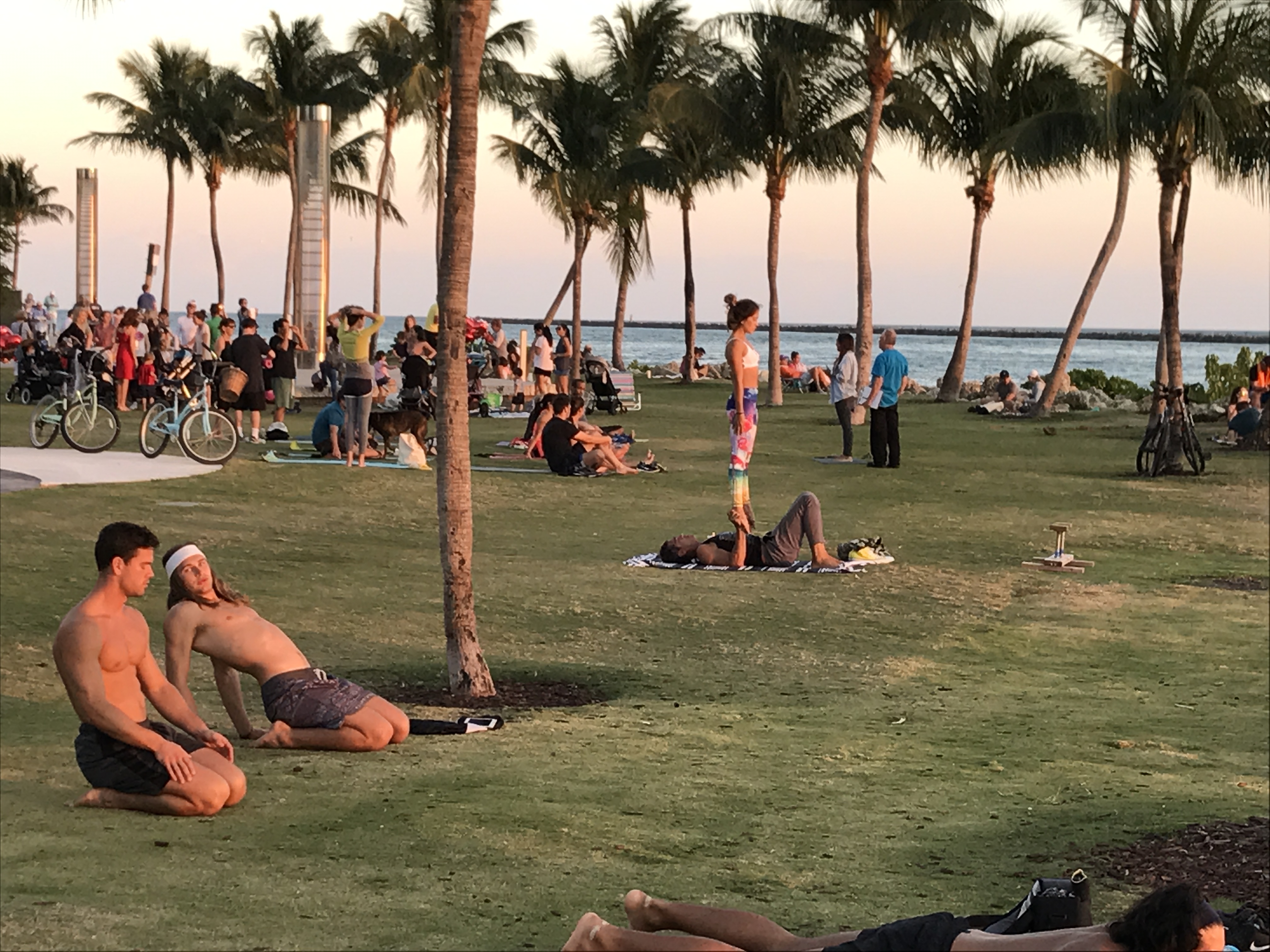 Visitors enjoying South Pointe Park at sunset with lush tropical landscaping and waterfront views
