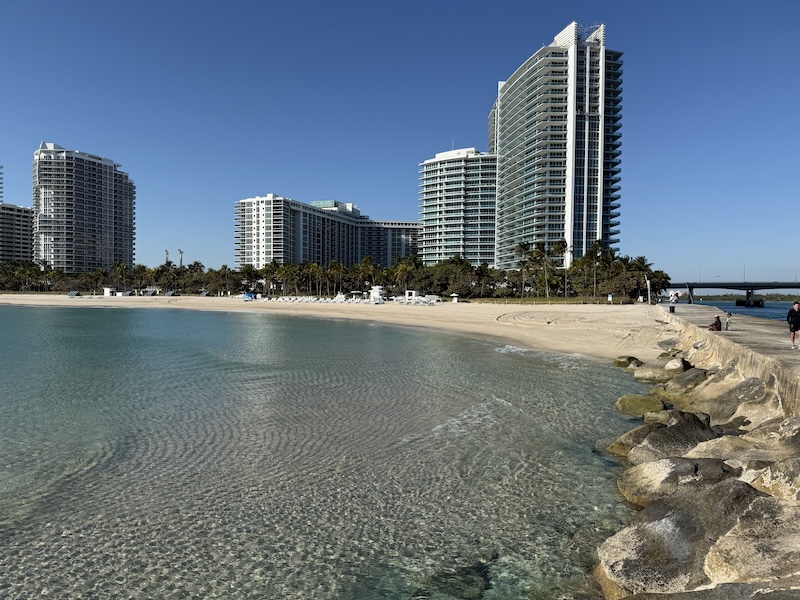 Panoramic view of Bal Harbour oceanfront with crystal-clear turquoise water, sandy beach, and luxury condominium skyline